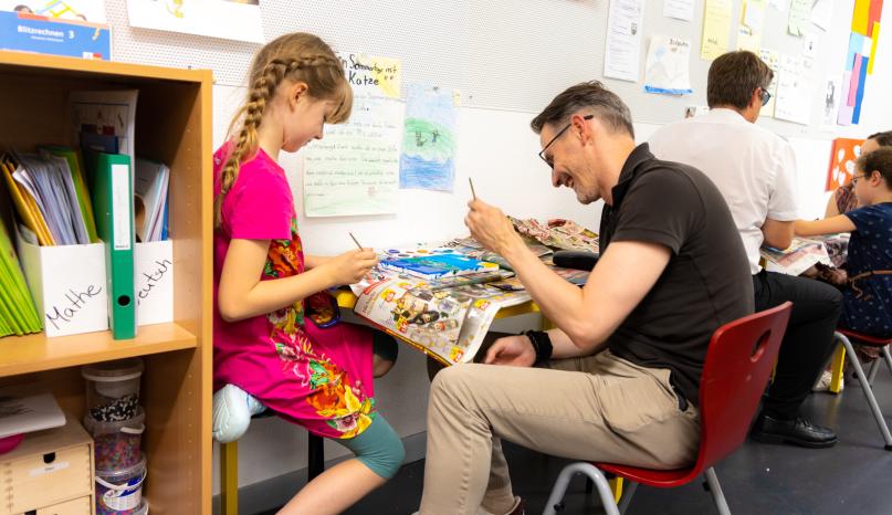 Mann mit Tochter beim Malen im Klassenzimmer