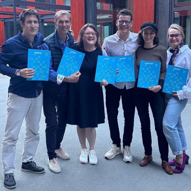 Foto einer Gruppe. Alle mit Zertifikatsmappen in der Hand.